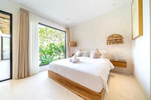 a bedroom with a large bed and a large window at Casa Myla Luxury Villa - Bingin in Badung +31 photos