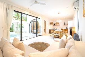 a living room with a white couch and a dining room at Casa Myla Luxury Villa - Bingin in Badung
