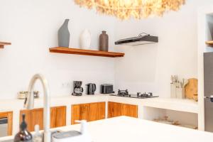 a kitchen with white walls and wooden cabinets at Casa Myla Luxury Villa - Bingin in Badung