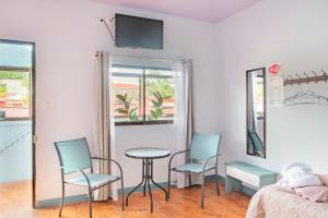 a room with two chairs and a table and a bed at Red Frog Rooms in Fortuna