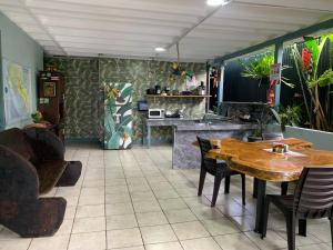 a dining room with a table and a kitchen at Red Frog Rooms in Fortuna