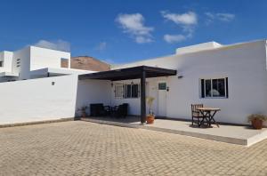 a white building with a patio with a table on it at Can Blum in La Asomada