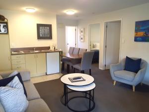 a living room with a couch and chairs and a table at Tuscana Motor Lodge in Christchurch