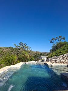 a swimming pool with blue water in a resort at Pura Vista Lodge in Sámara