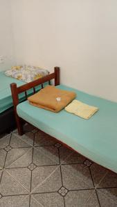 a bed with two blankets on top of it at Pousada Vó Ana Reis in Aparecida
