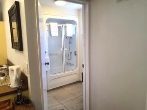 a bathroom with a shower with a glass door at Tuscana Motor Lodge in Christchurch +44 photos