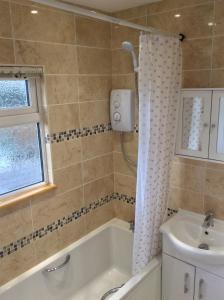 a bathroom with a bath tub and a sink at Dawn in Hemsby +66 photos