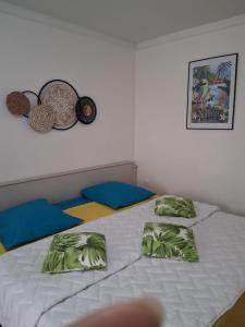 a bed with two pillows on top of it at Le Tropical in Sainte-Anne