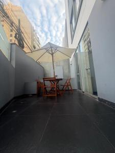 a table with an umbrella on top of a building at Miraflores Alcanfores in Lima