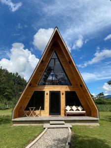 a frame house with a triangular roof on a field at Villa Alpina in Oxapampa
