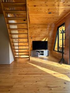 a room with a wooden ceiling with a flat screen tv at Villa Alpina in Oxapampa