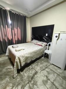 a bedroom with a bed and a small refrigerator at APART HOTEL Lar Doce Lar 2 & 7 in Arcos +14 photos