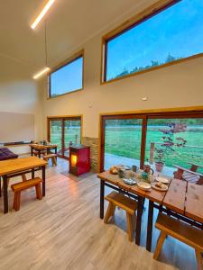 a living room with tables and a fireplace and windows at Hotel Neyün La Junta in La Junta