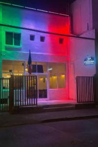 a building with colorful lights on the side of it at Hotel Italia in Ovalle