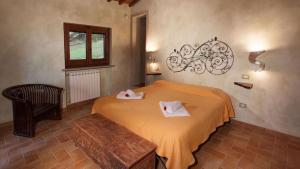 a bedroom with a bed with two towels on it at Umbria Genius Loci Farmhouse in Gaglietole +40 photos