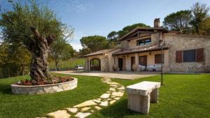 a house with a tree in the front yard at Umbria Genius Loci Farmhouse in Gaglietole
