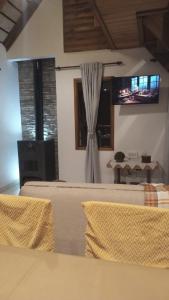 a room with two beds and a tv on the wall at Casa Cabaña Los Zorzales Santa Clara del Mar-Argentina in Santa Clara del Mar