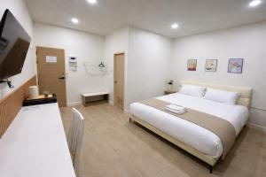 a bedroom with a large white bed and a table at MinimalYala in Yala