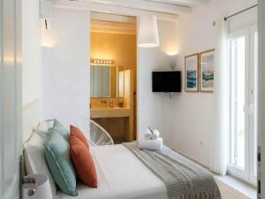 a bedroom with a bed with pillows and a television at Kalafatis Stay with Private Pool in Kalafatis