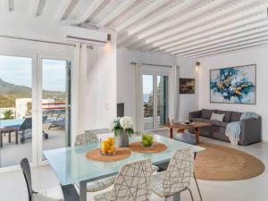 a white living room with a table and chairs at Kalafatis Stay with Private Pool in Kalafatis