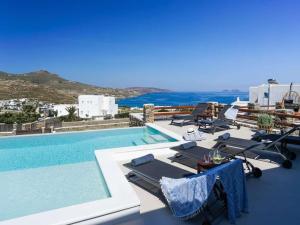 a swimming pool with lounge chairs and the ocean at Kalafatis Stay with Private Pool in Kalafatis