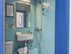 a bathroom with a sink and a shower at Mykonos Town Home for Two in Megali Ammos