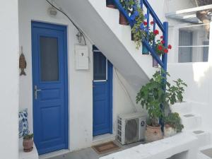 a blue door on a white building with plants at Mykonos Town Home for Two in Megali Ammos
