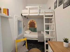 a small room with two bunk beds and a desk at Mykonos Town Home for Two in Megali Ammos