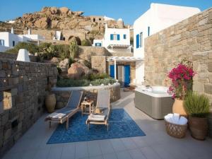 a patio with two chairs and a bath tub at Suite with Jacuzzi & Sea View in Mikonos