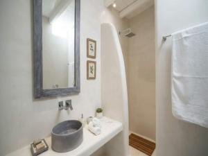 a bathroom with a sink and a mirror at Suite with Jacuzzi & Sea View in Mikonos +11 photos