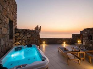 a jacuzzi tub on top of a stone building at Suite with Jacuzzi & Sea View in Mikonos
