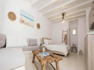 a white living room with a couch and a table at Suite with Jacuzzi & Sea View in Mikonos