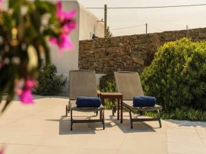two chairs with blue cushions sitting on a patio at Ano Mera Villa with Private Pool in Ano Mera