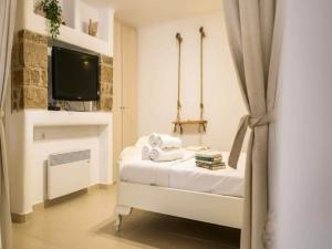 a bedroom with a bed with a tv on a wall at Ano Mera Villa with Private Pool in Ano Mera