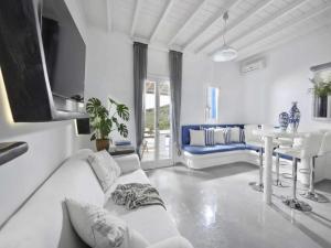a living room with a white couch and a table at Panormos Retreat with Pool in Mikonos