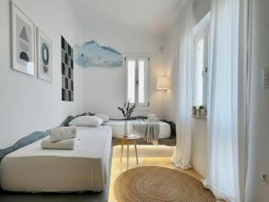 a white room with two beds and a rug at Panormos Retreat with Pool in Mikonos +41 photos