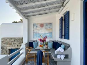 a porch with blue and white furniture and a table at Panormos Retreat with Pool in Mikonos