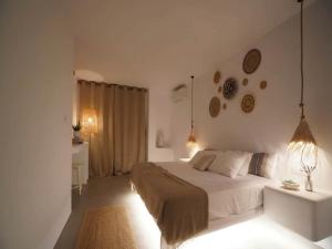 a white bedroom with a bed and a desk at Panormos Stay for Seven Guests in Mikonos +19 photos