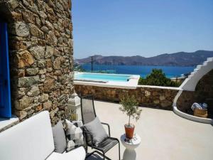 a patio with two chairs and a swimming pool at Panormos Stay for Seven Guests in Mikonos