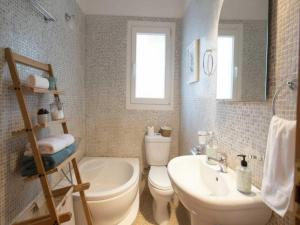 a bathroom with a toilet and a sink and a tub at 3-Bed Home in Ano Mera in Ano Mera +18 photos