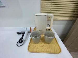 a blender sitting on a counter with two measuring cups at MinimalYala in Yala