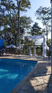 a swimming pool with a gazebo and a tent at Estância 7 praias in São Paulo