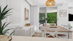 a kitchen and dining room with a table and chairs at Sea Glass in Terrigal
