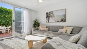 a living room with a couch and a table at Sea Glass in Terrigal +16 photos