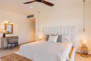 a bedroom with a large white bed with a ceiling fan at Kokkari Villa in Kokkari