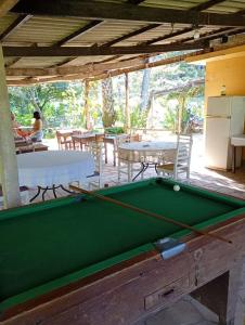 a pool table in a room with tables and chairs at Pousada Quintal da Cachoeira in São Thomé das Letras