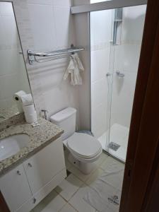 a bathroom with a toilet and a glass shower at Apartamento Veredas Flat - Rio Quente in Rio Quente +36 photos