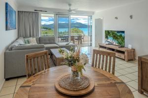 a living room with a table and a couch at Poinciana 106 in Hamilton Island