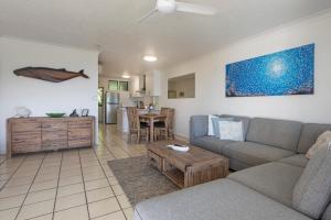 a living room with a couch and a table at Poinciana 106 in Hamilton Island