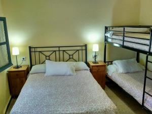 sypialnia z 2 łóżkami piętrowymi i 2 lampami w obiekcie Pensión La Montoreña w Sewilli